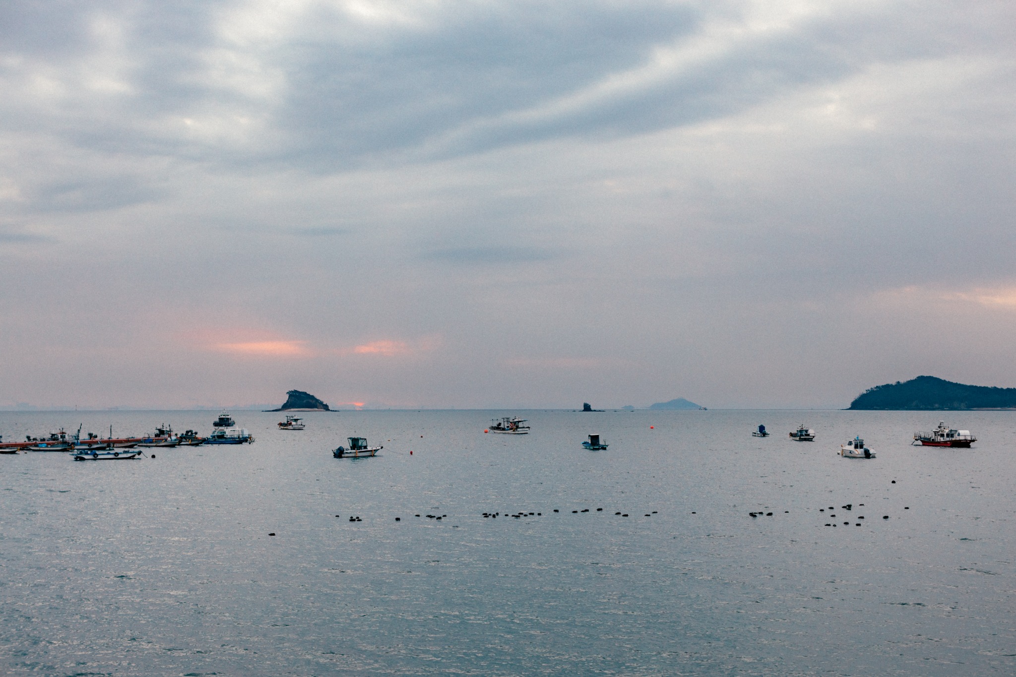 Fishing boats beneath a pale evening sky