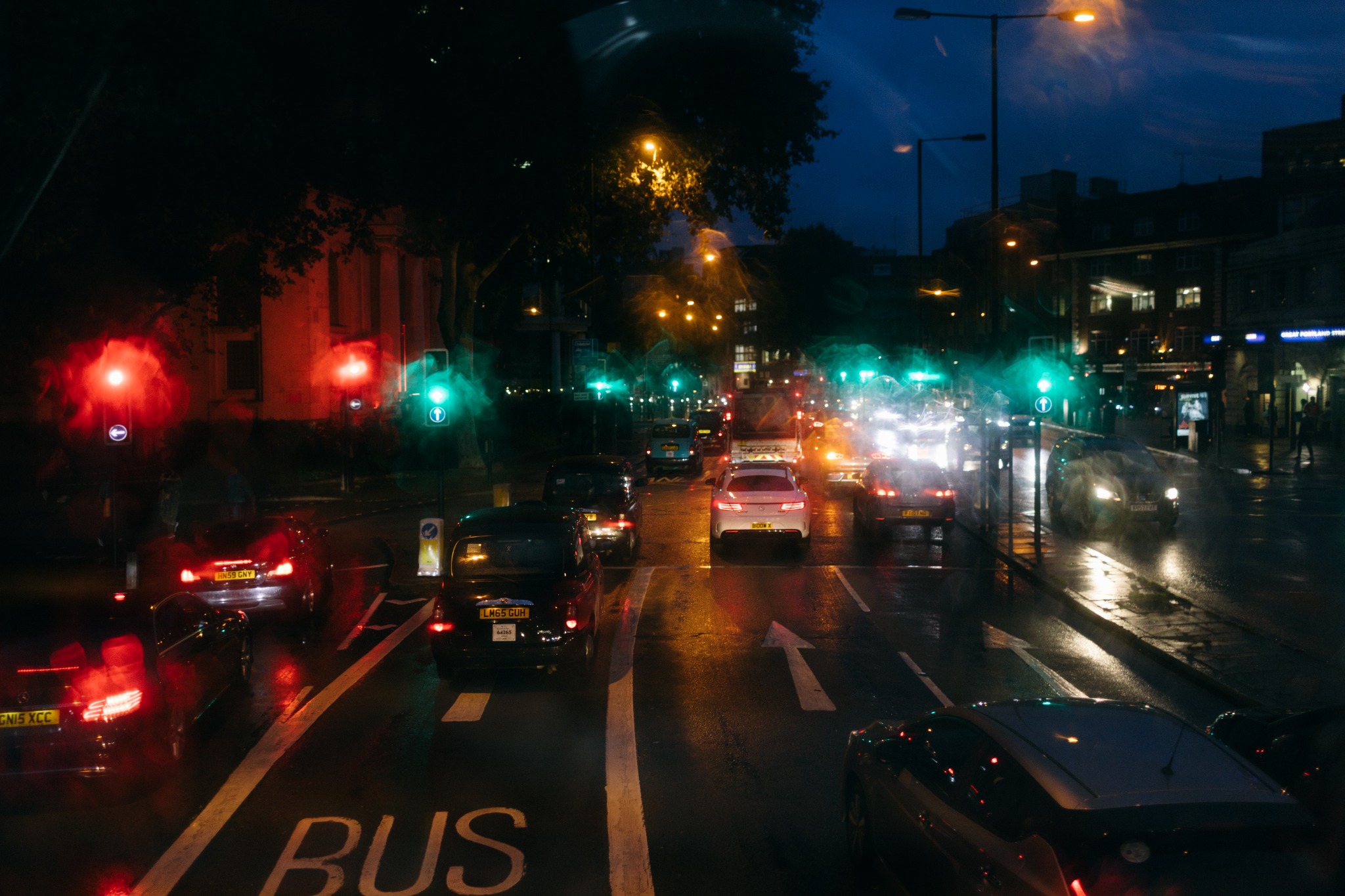 Traffic and coloured lights on a wet city road at blue hour